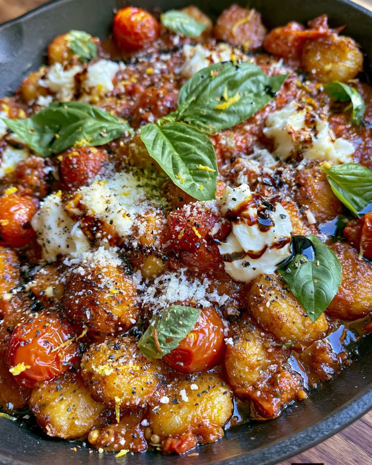 Smashed Gnocchi Skillet with crispy golden gnocchi, cherry tomatoes, creamy burrata, Parmesan, basil, and balsamic glaze