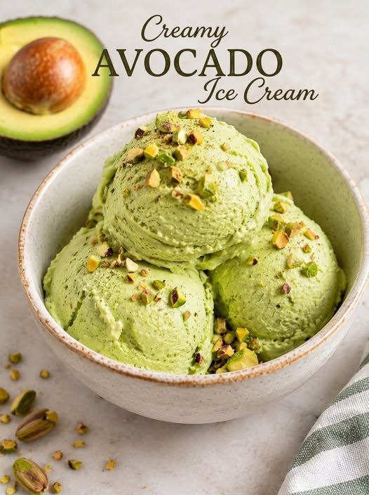 Creamy Avocado Ice Cream served in a ceramic bowl with three pale-green scoops topped with chopped pistachios.