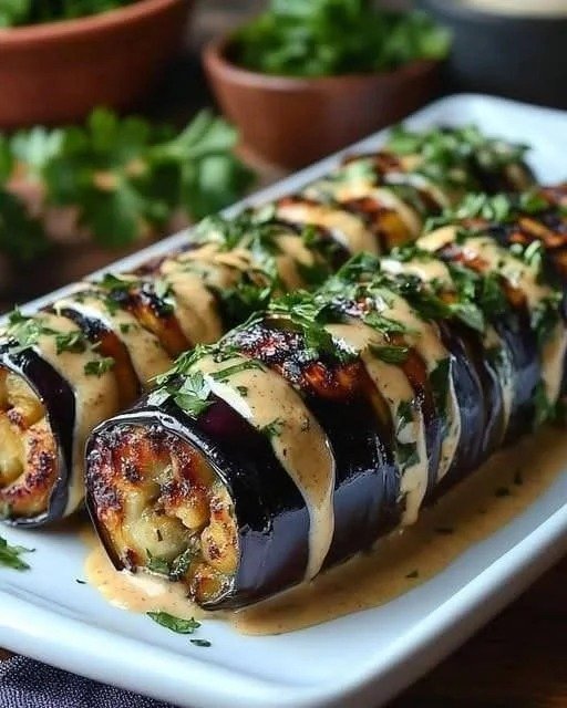 Mediterranean Eggplant Rolls filled with ricotta and feta cheese in tomato sauce with fresh herbs