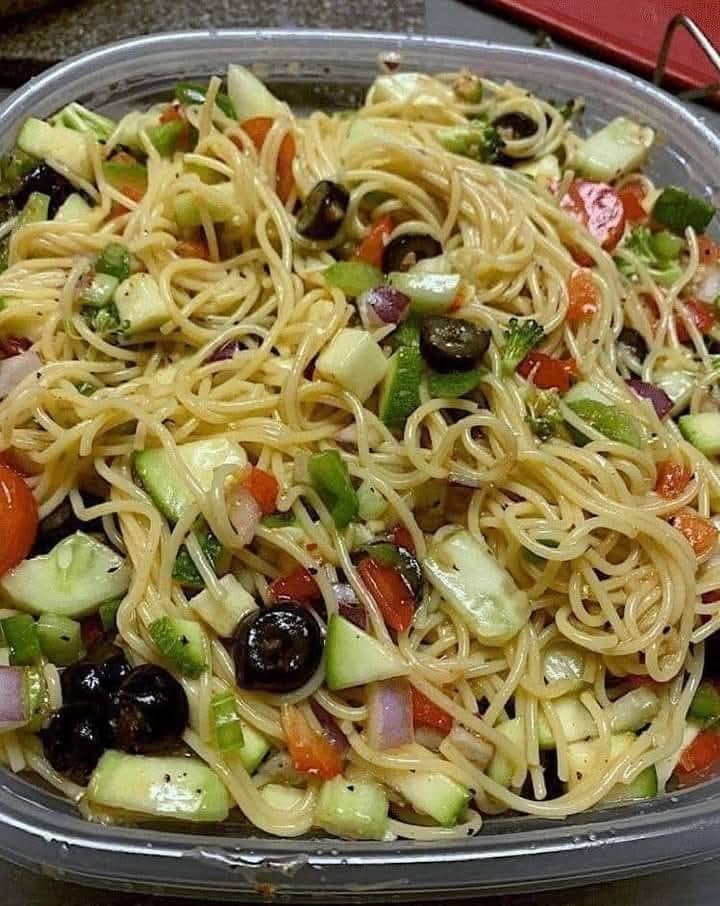 Spaghetti Pasta Salad with cucumber, tomatoes, bell peppers, black olives, red onion, Parmesan, and Italian dressing